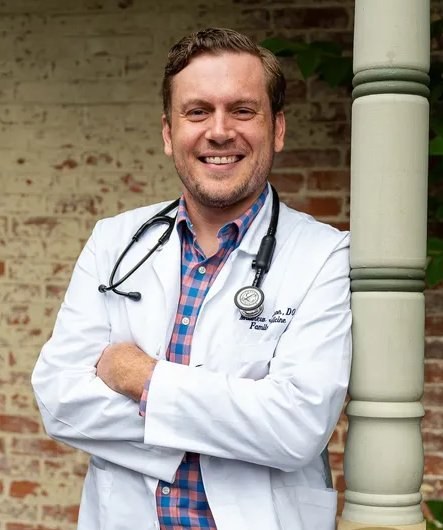 Dr. Matthew Johnson, founder of Ridgeline Consultants, in a white coat with a stethoscope